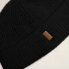 Berretto in lana nera con etichetta in pelle “Ami”