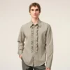 Camicia aderente con volant a maniche lunghe in cotone beige Camicia aderente con volant a maniche lunghe in cotone beige