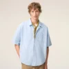 Camicia Ami de Coeur a maniche corte in cotone blu dal taglio squadrato Camicia Ami de Coeur a maniche corte in cotone blu dal taglio squadrato
