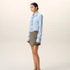 Camicia blu in cotone a maniche lunghe con volant e vestibilità aderente Camicia blu in cotone a maniche lunghe con volant e vestibilità aderente